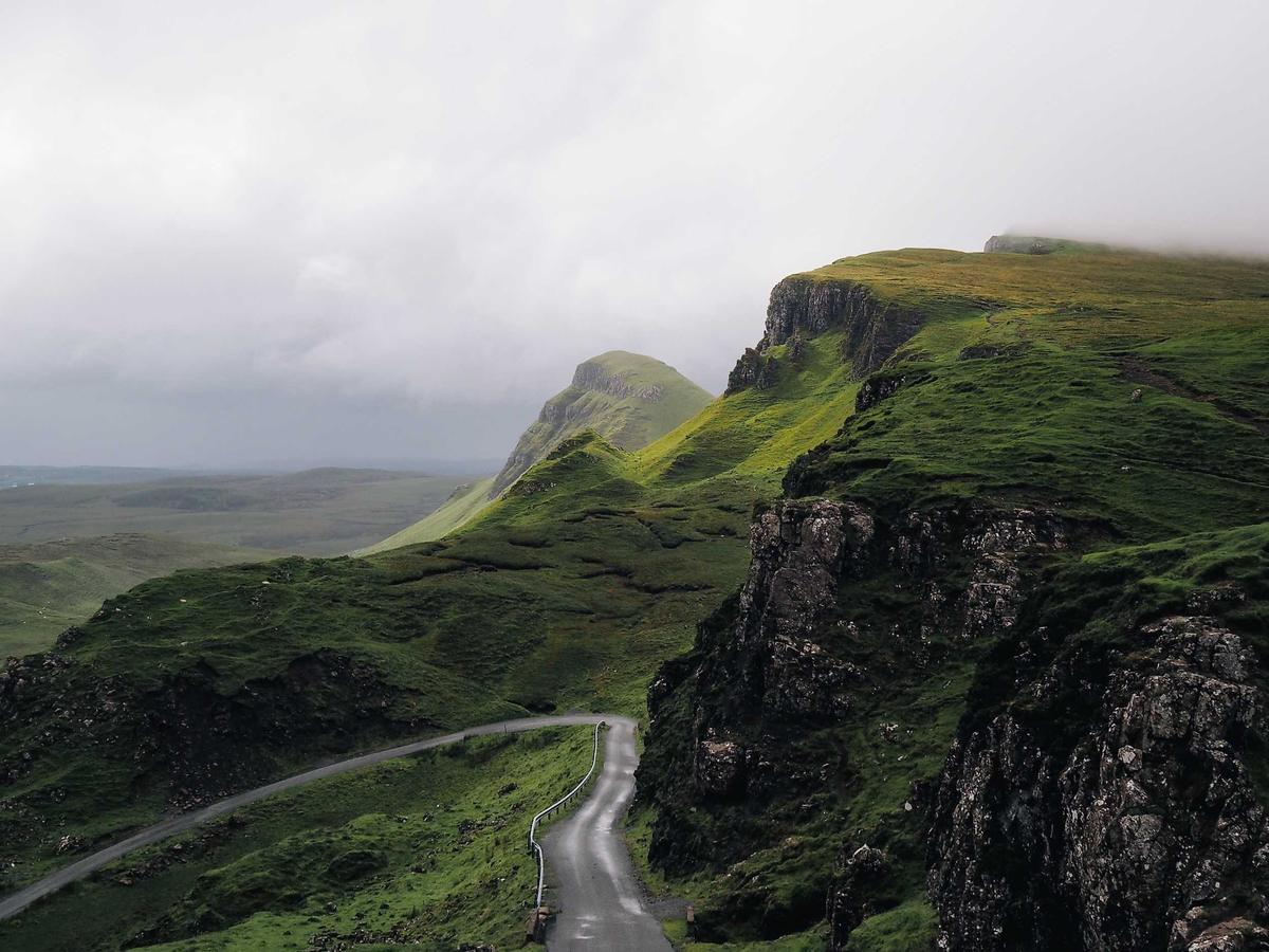 A green valley beneath distant mountains